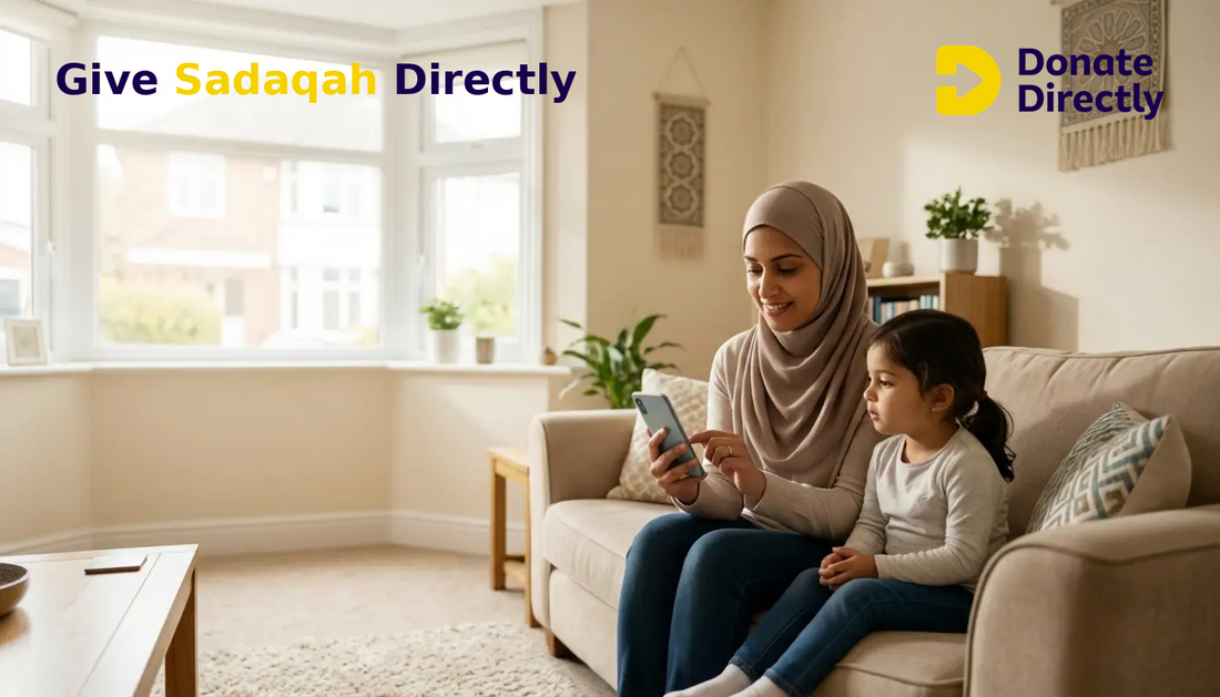 British Muslim mother giving Sadaqah by phone at home with her child nearby.