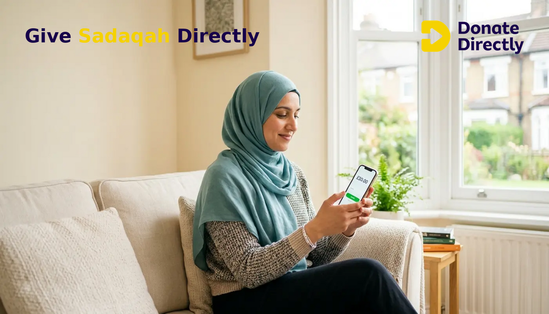 British Muslim woman giving Sadaqah on her phone in a bright UK living room