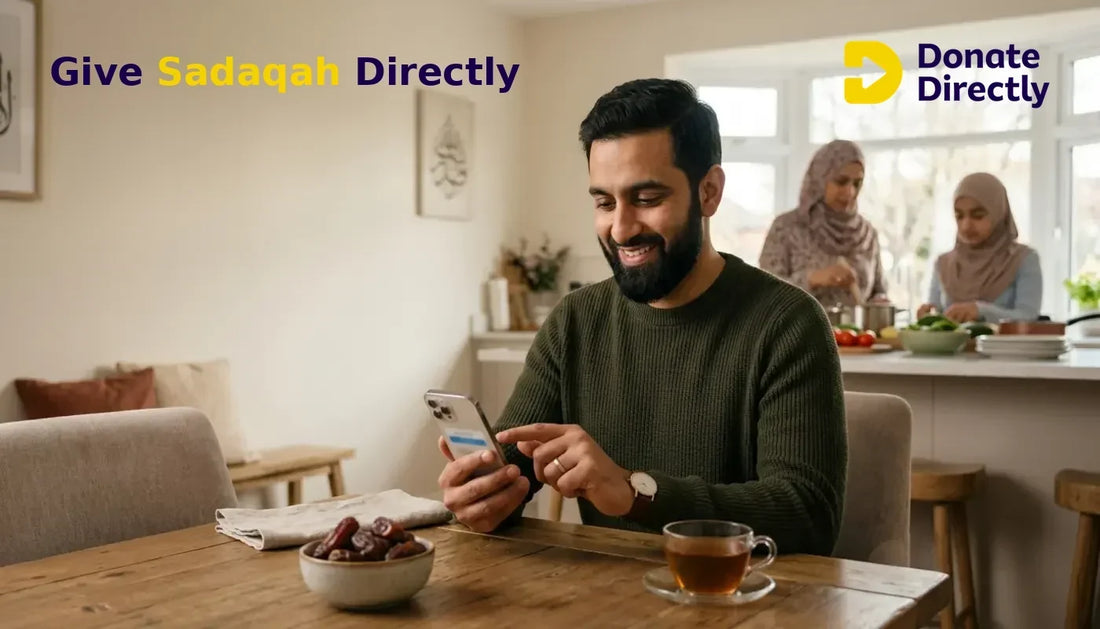 British Muslim father giving Sadaqah online at a bright Ramadan family table.