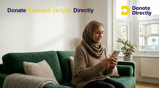 UK Muslim donor giving Sadaqah Jariyah on a phone in a warm home setting