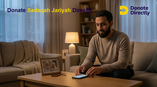 Muslim donor in UK home giving Sadaqah Jariyah in memory of parents using phone in a warm reflective setting.
