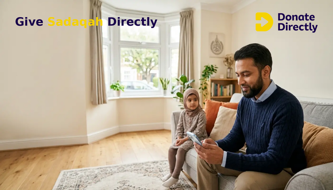 British Muslim father giving Sadaqah on a phone in a bright UK Muslim home.