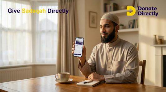 UK Muslim donor giving Sadaqah on phone in a warm home setting
