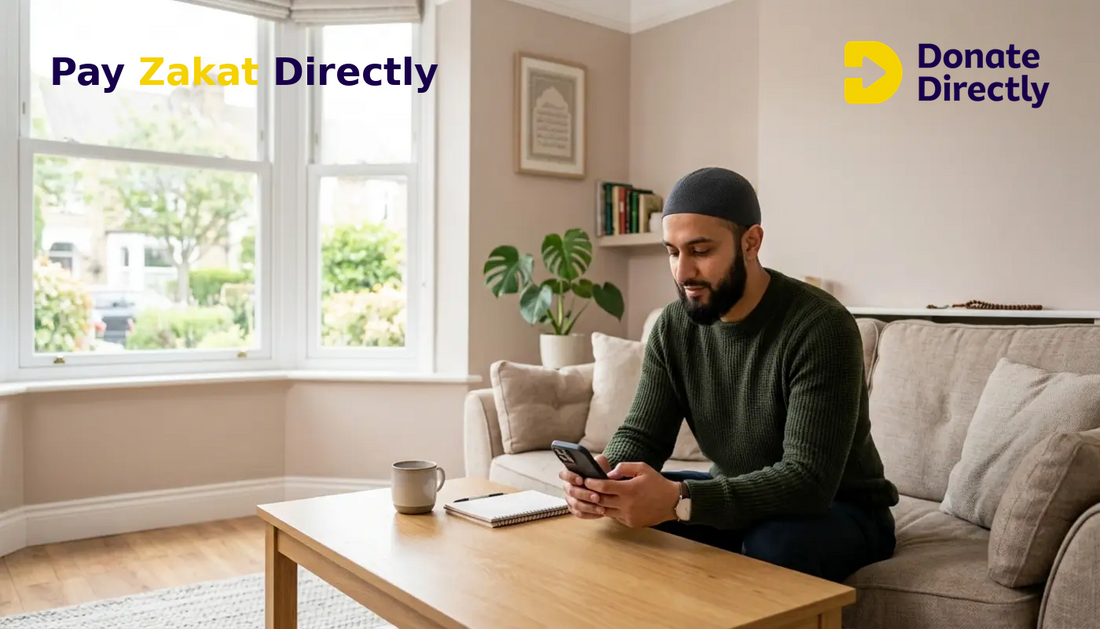 British Muslim man paying Zakat on phone in a bright UK living room