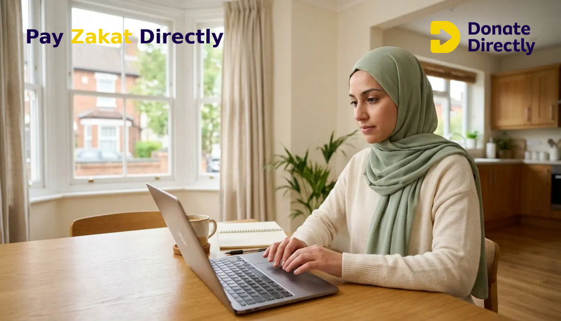 British Muslim woman calculating Zakat on savings in a bright UK home kitchen.